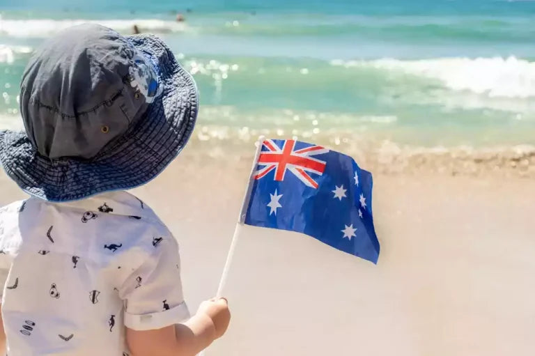 little boy with australian flag near the ocean